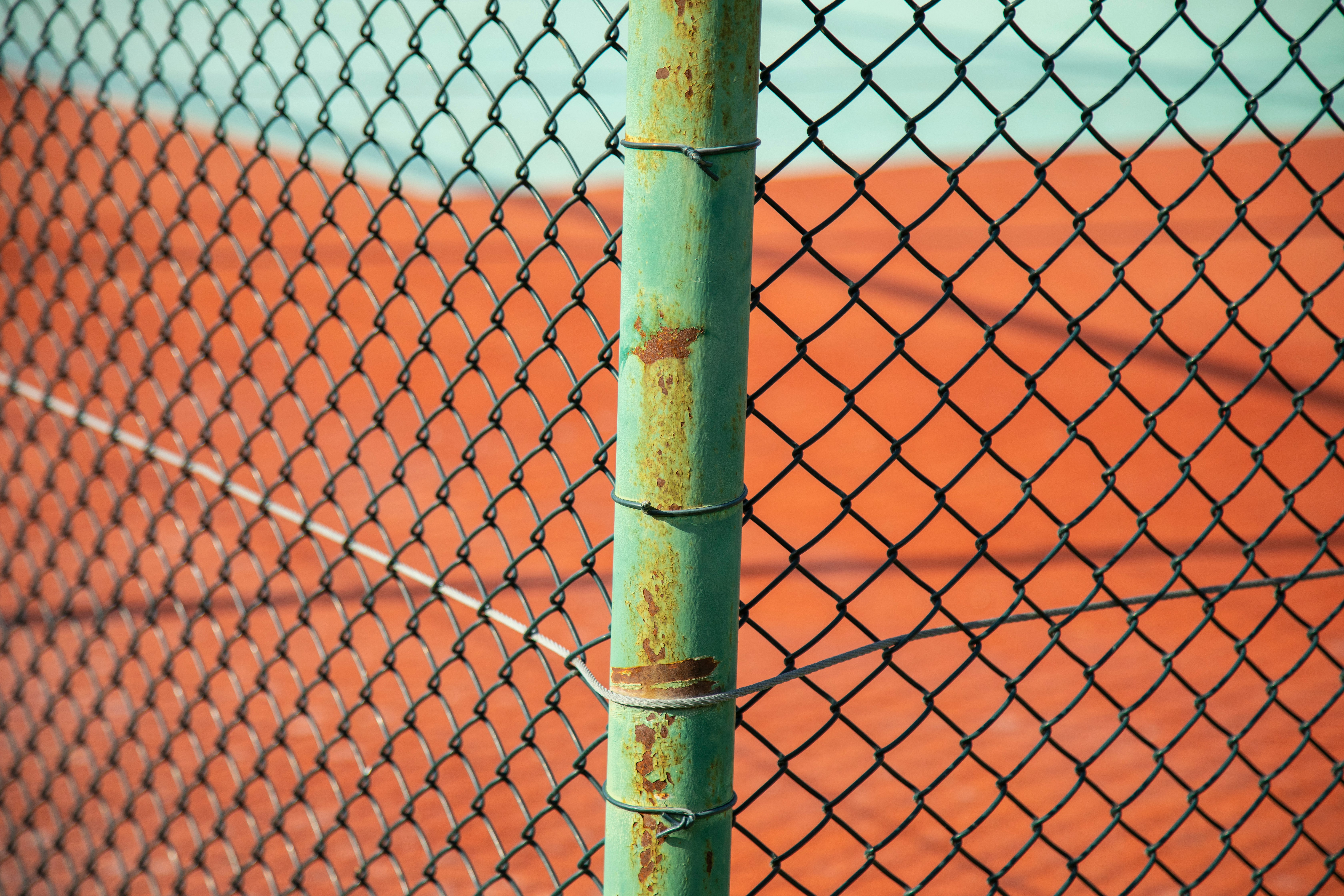 brown wooden pole with chain link fence